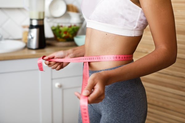 girl measuring waist for slimming treatment