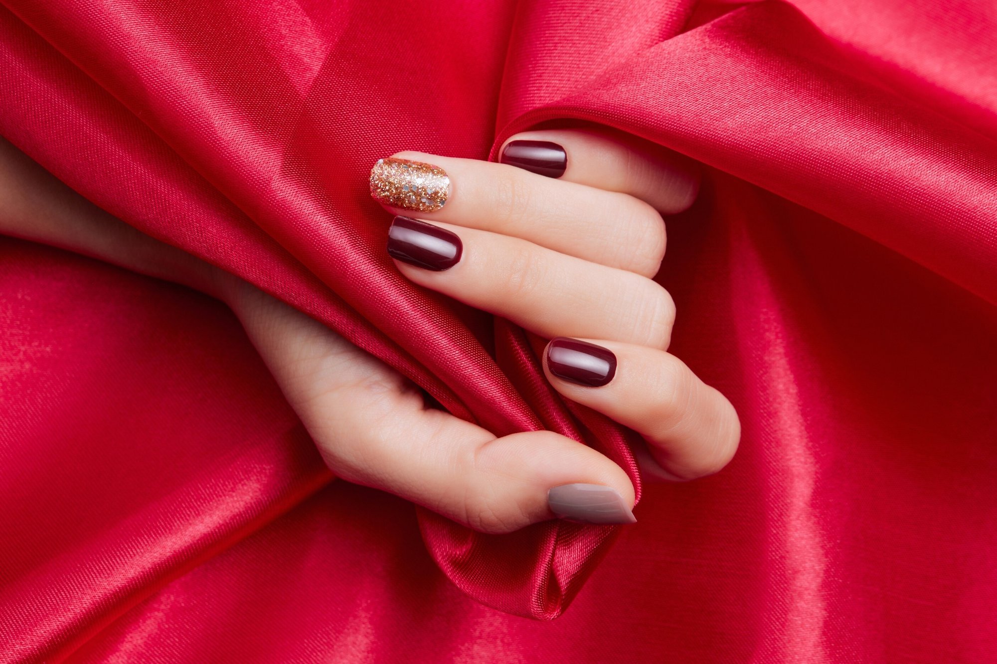 closeup-shot-female-s-hand-with-beautiful-nail-polish-caressing-red-silk-fabric (1) (1) (1)