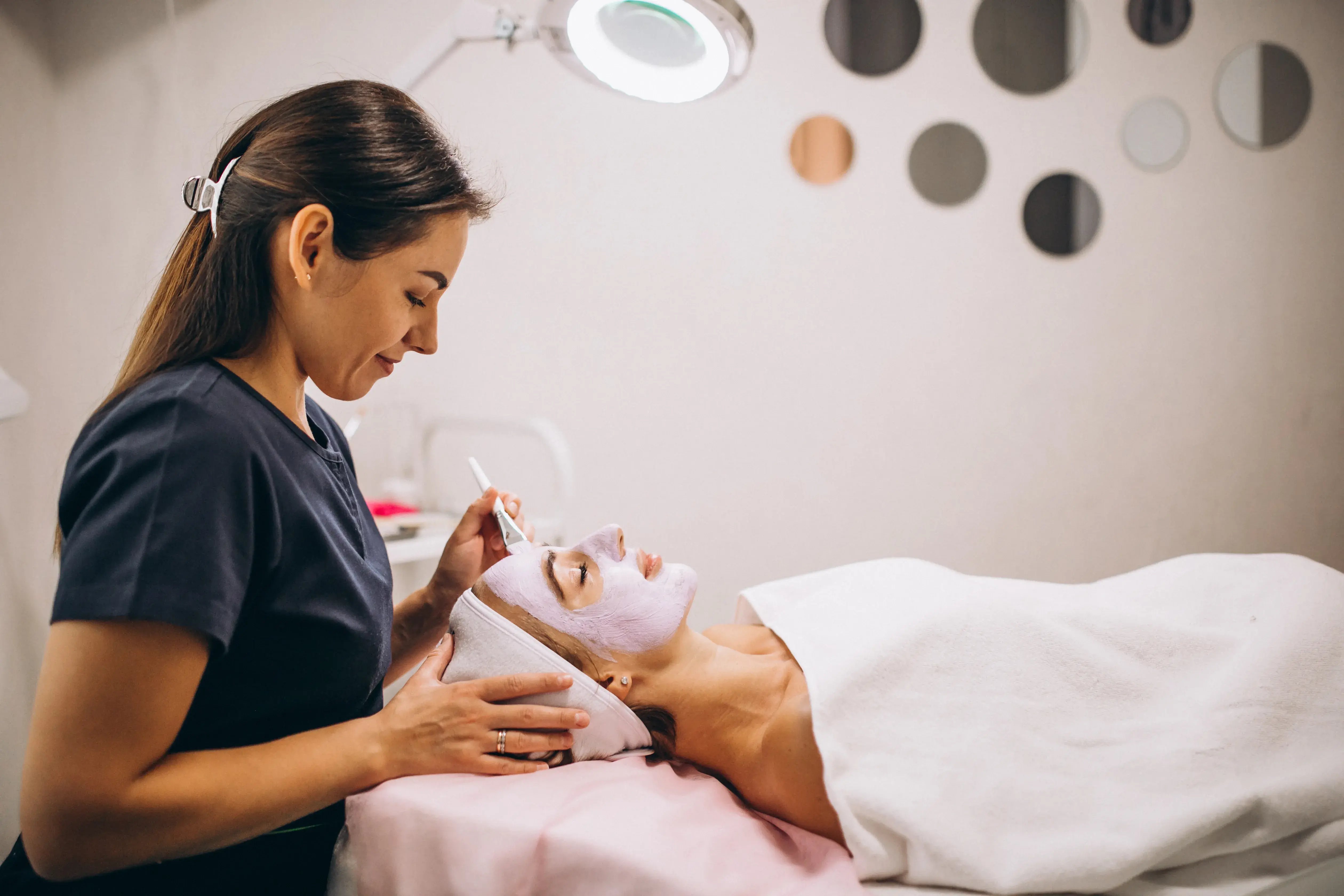 cosmetologist-applying-mask-face-client-beauty-salon