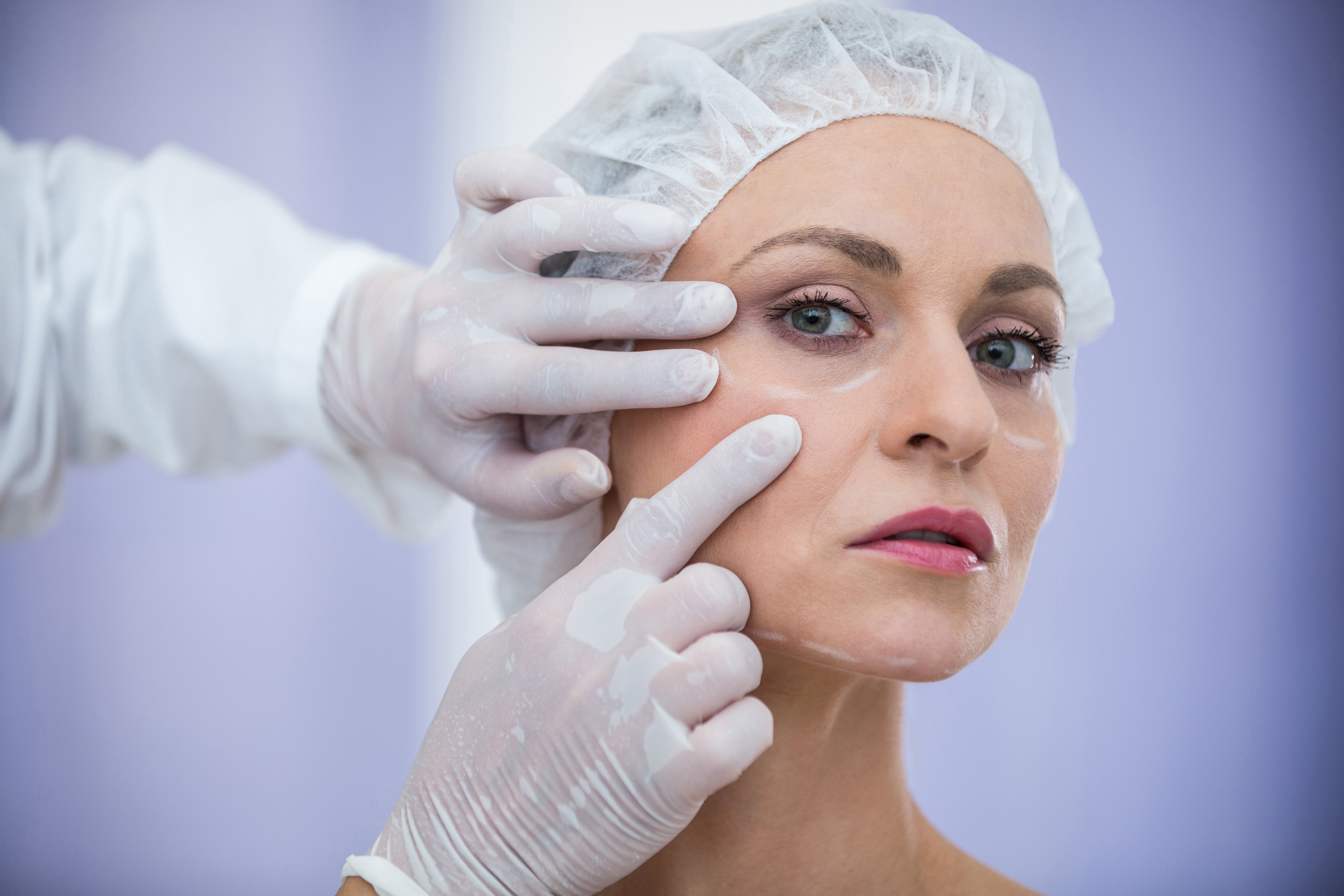 doctor-examining-female-patients-face-cosmetic-treatment
