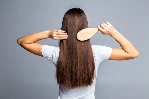 Woman brushing smooth, healthy hair after GFC treatment