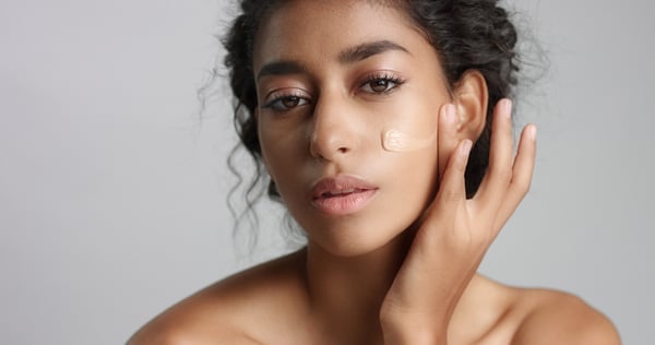 middle-eastern-young-woman-studio-with-foundation-cheek-closeup-touching-skin