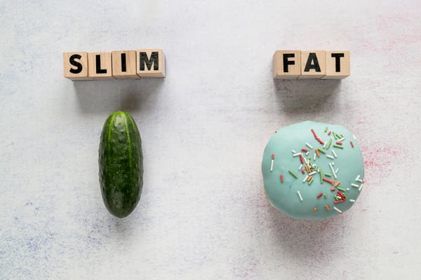 slim-fat-text-wooden-blocks-with-cucumber-glazed-donut-rough-backdrop