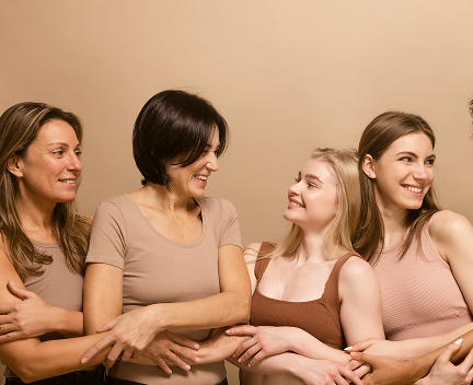 beautiful-ladies-different-ages-nations-brown-tops-look-each-other-holding-hands-beige-background 1