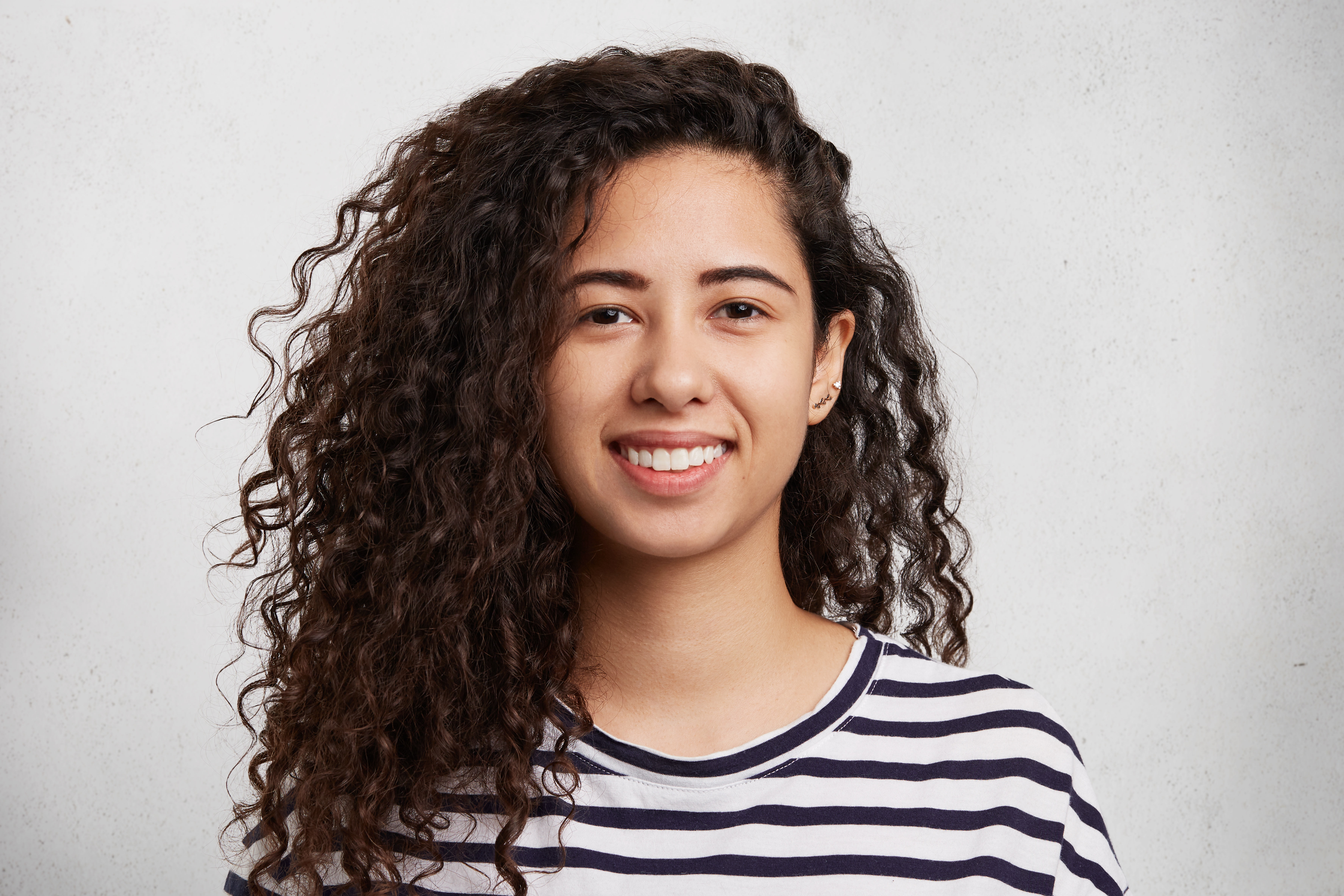 Happy woman touching her wavy hair