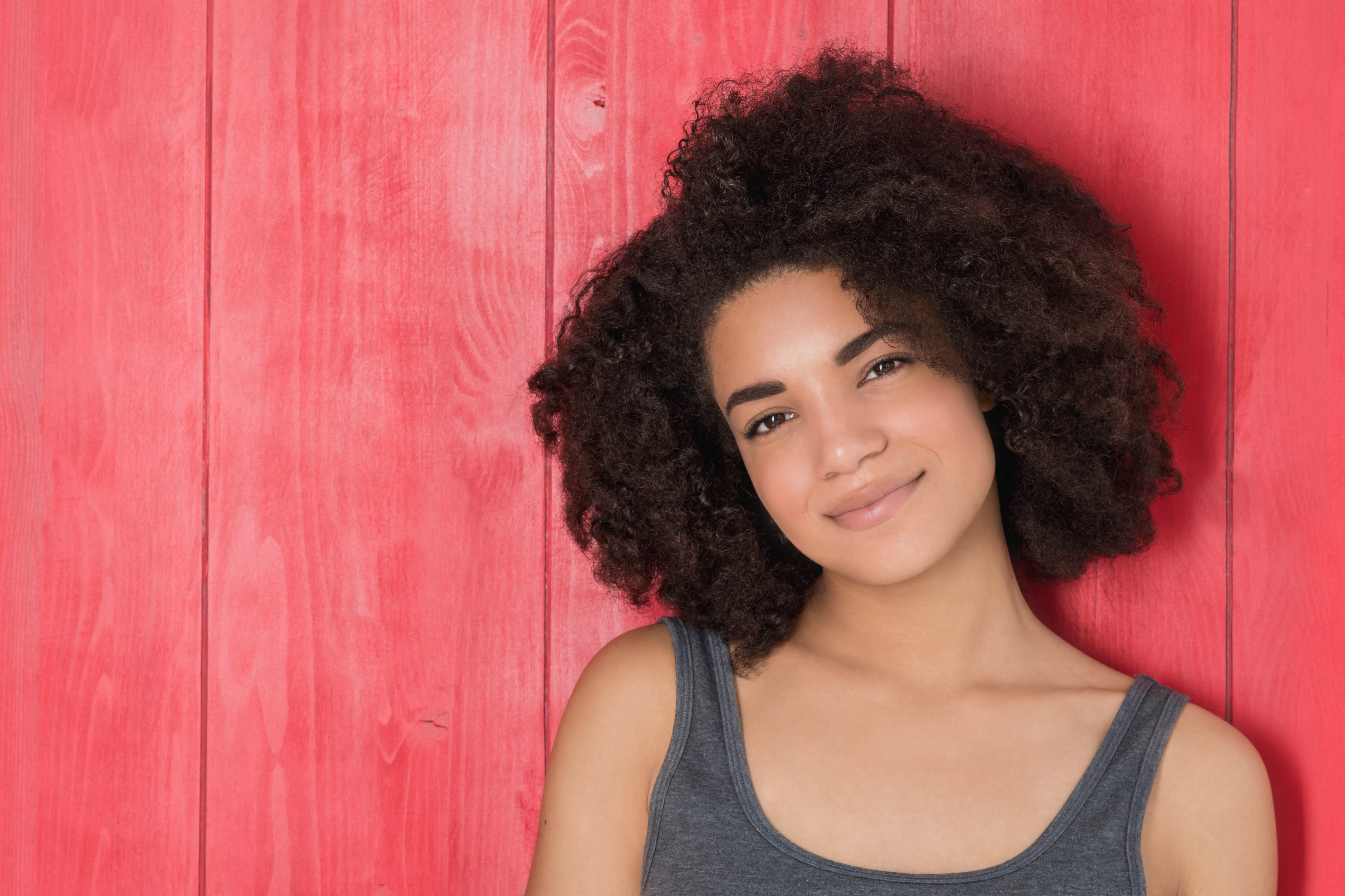 Smiling woman with curly hair.