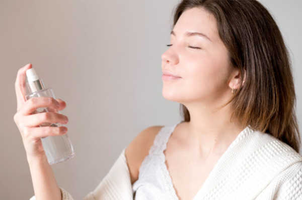 Woman using facial toner spray