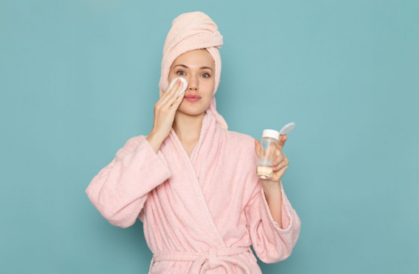 Woman applying toner to her face