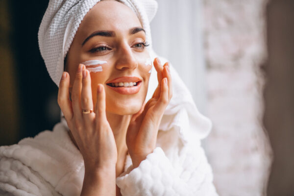 Woman applying sunscreen on her face